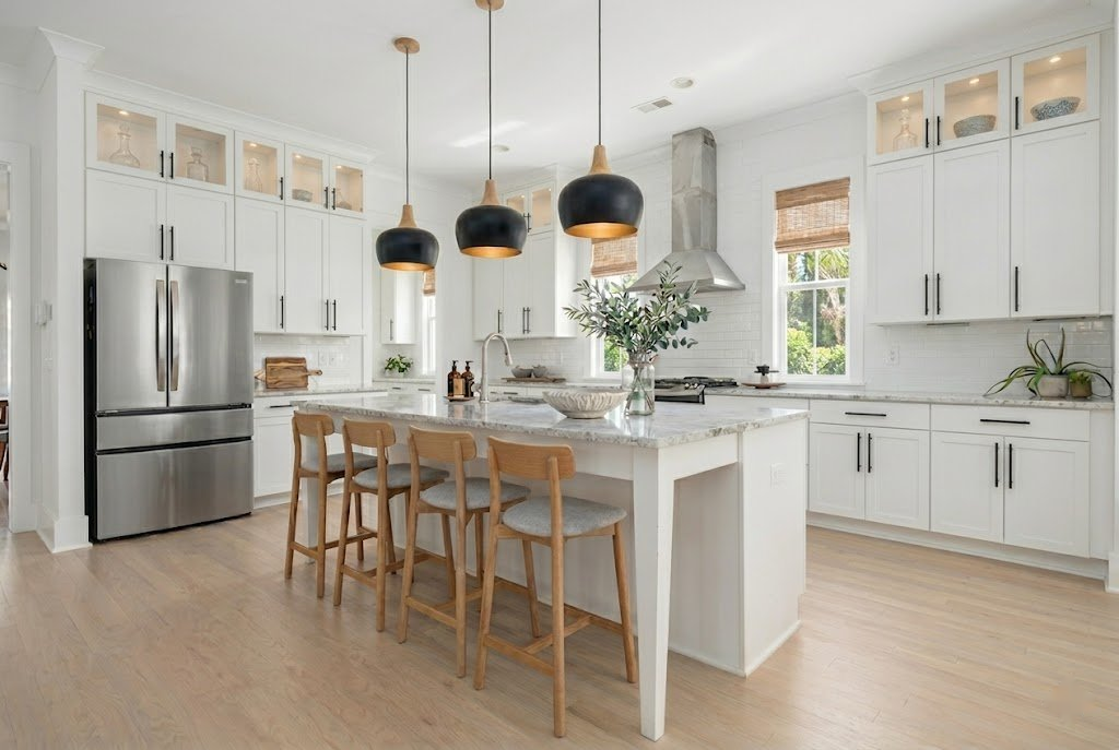 Light coastal kitchen with white cabinetry, white oak floors, and natural wood seating